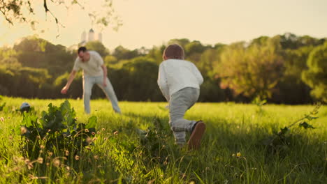 Vater-Steht-Am-Tor-Und-Spielt-Bei-Sonnenuntergang-Mit-Seinem-Sohn-Fußball.-Der-Vater-Trainiert-Das-Kind-Auf-Dem-Feld.-Der-Junge-Schlägt-Den-Ball